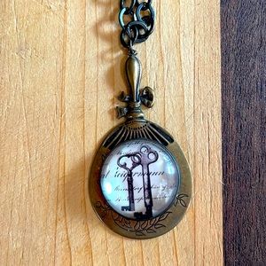 Brass fan pendant necklace with image of skeleton keys and script